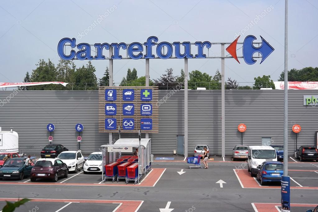 SAINT-LO, FRANCE - JULI 2014 - Facade and parking of a Carrefour hypermarket - Carrefour is a French multinational retailer, It is one of the largest hypermarket chains in the world
