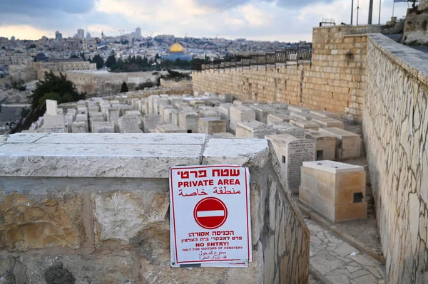 Private area sign at Mount of Olives Jewish Cemetery in the background the Temple Mount.