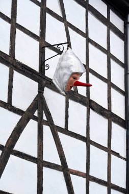 Uzun kırmızı burunlu masker, Blancs-Moussis, Stavelot kasabasındaki yarı keresteli bir binadan sarkan geleneksel bir karnaval özelliği.