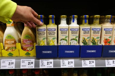 ALMANY - Ekim 2022 Rewe süpermarketinde salata sosu seçen tüketici. Thomy, Nestl 'e ait bir İsviçre gıda markası.