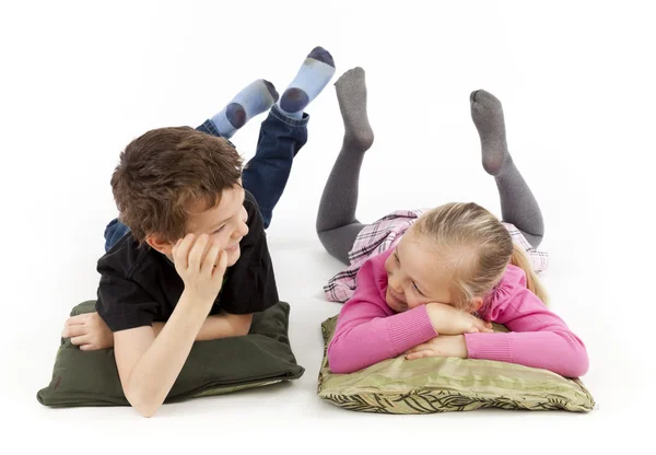 Girl and Boy lying on pillows — Stock Photo, Image