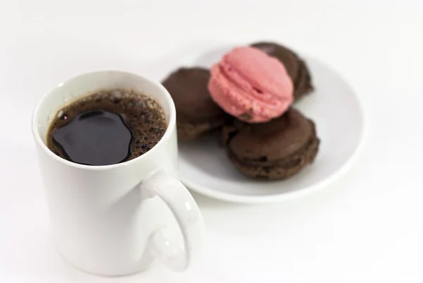 Xícara de café com macaroons em tom marrom e rosa sobre fundo branco — Fotografia de Stock
