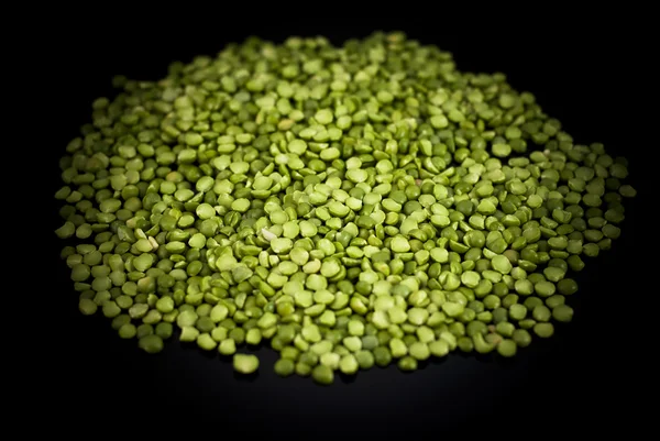 Green peas on a black background — Stock Photo, Image