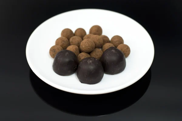 Schokoladentrüffel auf schwarzem Hintergrund — Stockfoto