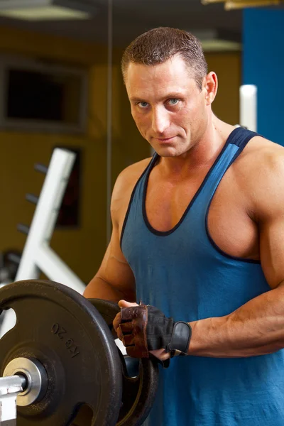 Hombre fuerte preparando su máquina de entrenamiento en forma —  Fotos de Stock