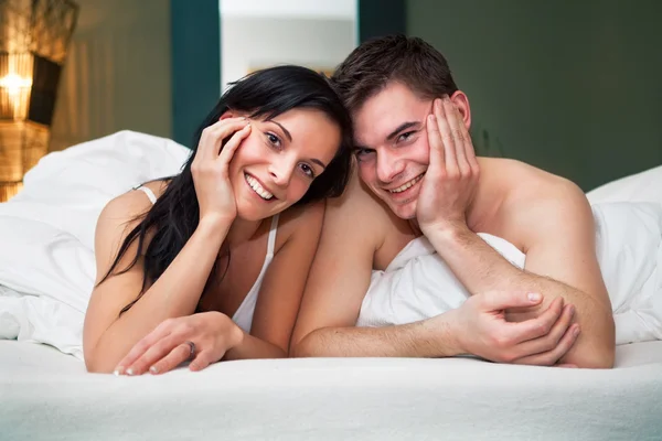 Закройте вид на смеющуюся пару в спальне — стоковое фото