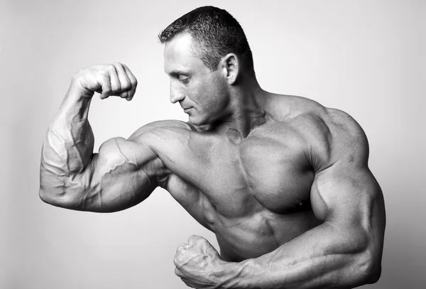 Hombre musculoso flexionando sus bíceps —  Fotos de Stock