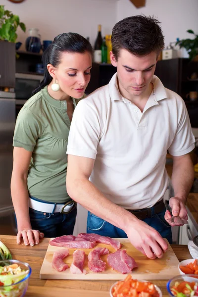 Jeune couple préparant le déjeuner en cuisine — Photo