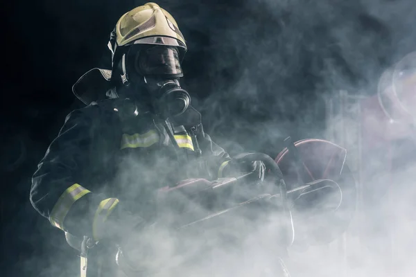 Портрет Пожарного Полном Защитном Снаряжении Позирующего Бензопилой Плече Темный Фон — стоковое фото