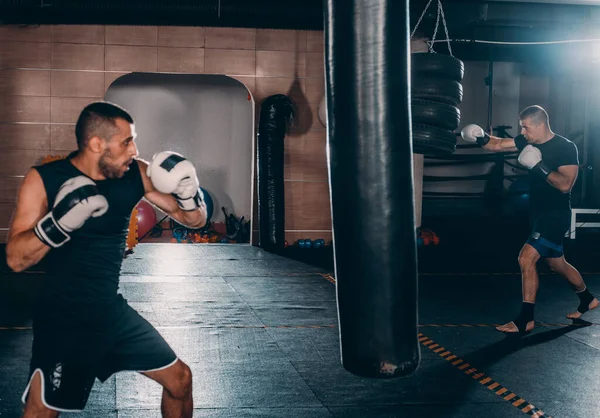 Forte Kickboxer Homem Perfurando Saco Areia Preta Fundo Ginásio — Fotografia de Stock