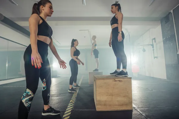 Sopii Nuorille Naisille Tekemässä Laatikko Kyykky Harjoituksia Crossfit Kuntosalilla — kuvapankkivalokuva