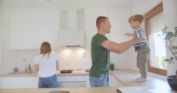 Hijo Salta Los Brazos Sus Padres Mesa Cocina — Vídeos de Stock