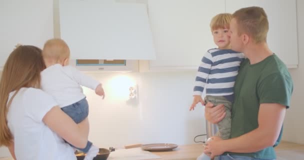 Jovens Pais Estão Divertindo Cozinha Abraçando Seus Filhos — Vídeo de Stock
