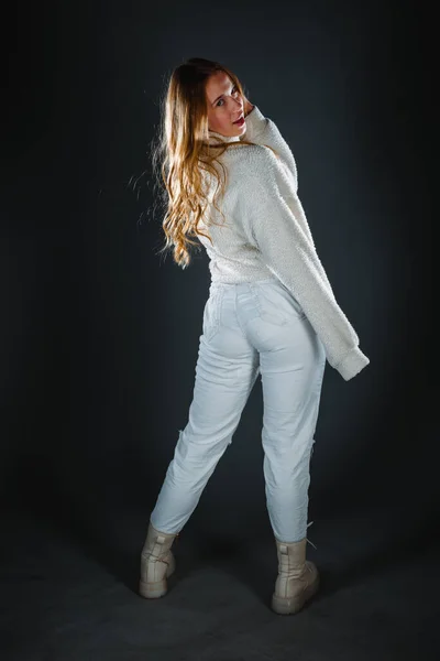一个穿着白色牛仔裤 头戴深色背景运动衫的小女孩 — 图库照片