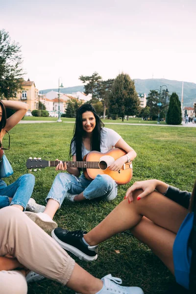 Güzel Terbiyeli Kız Arkadaşlarıyla Eğlenirken Gülümsüyor Gitar Çalıyor — Stok fotoğraf