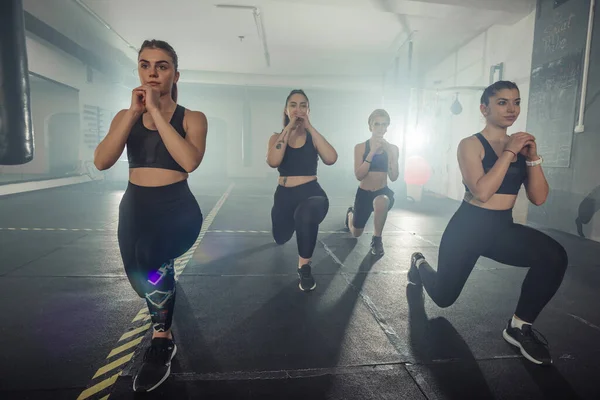 Spor Kıyafetli Bir Grup Kadın Spor Salonunda Sol Bacağıyla Atlama — Stok fotoğraf