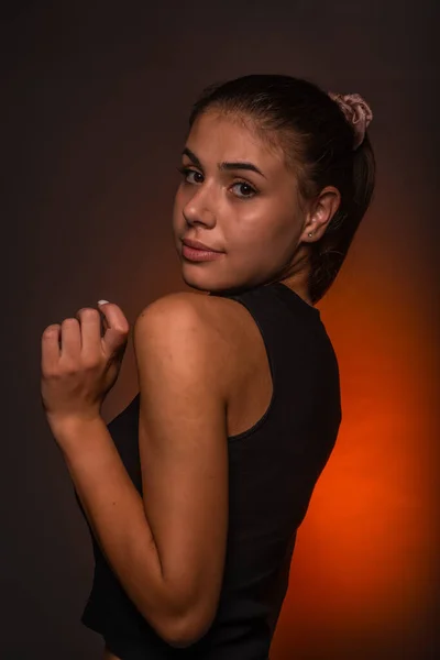 오렌지 빛으로 스튜디오에 포즈를 취하는 매력적 귀여운 소녀의 — 스톡 사진