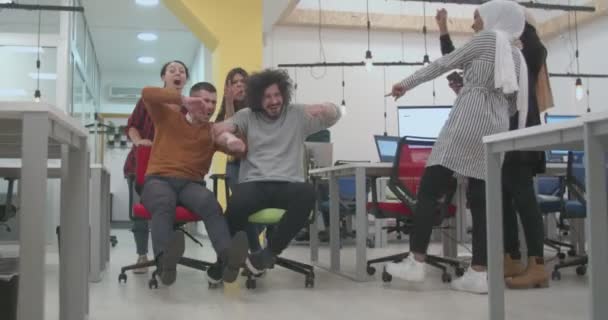 Een Groep Multiraciale Collega Duwt Hun Bureaustoelen Door Het Kantoor — Stockvideo