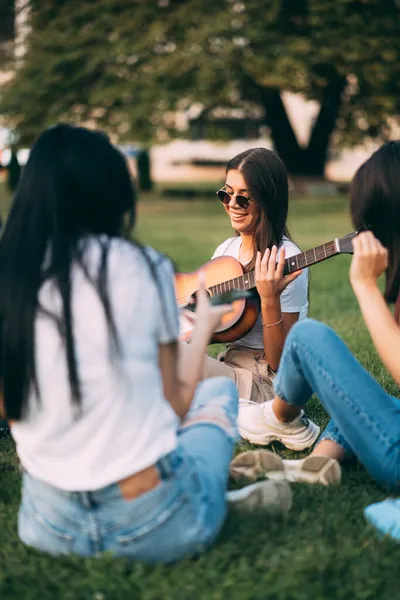 美しく素晴らしい女の子は ギターを演奏する準備をしながら笑っています — ストック写真