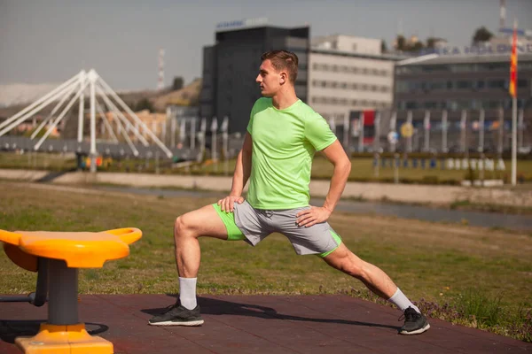 Schöner Kerl Dehnt Seine Beine Vor Seinem Training Draußen — Stockfoto