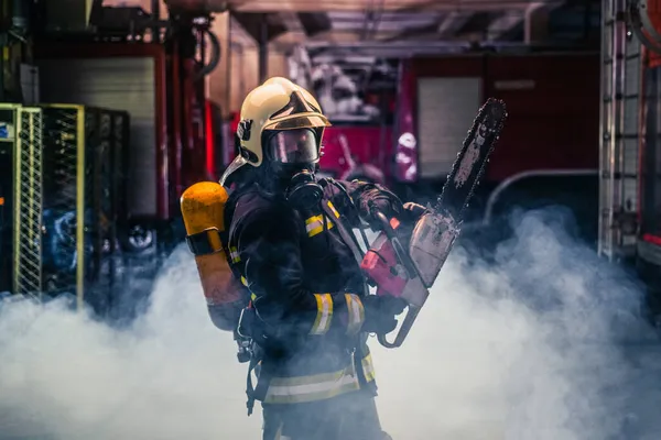 Portrait Young Fireman Standing Holding Chainsaw Middle Chainsaw Smoke — Stock Photo, Image