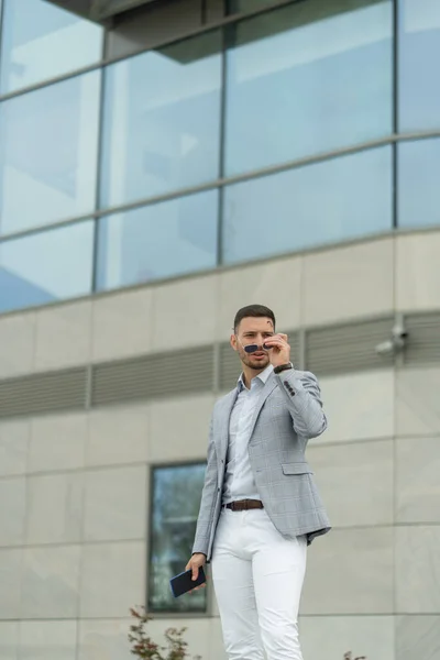 Städtischer Geschäftsmann Setzt Seine Sonnenbrille Auf Während Über Das Unternehmen — Stockfoto
