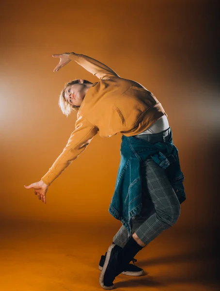 在橙色演播室里表演舞蹈的肌肉男舞蹈演员 — 图库照片