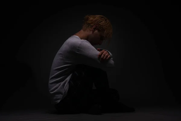 落ち込んでいる少年は座って悲しみを考えている — ストック写真