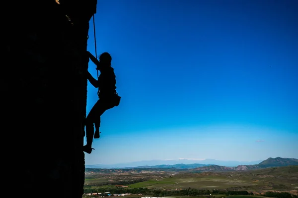 Genç Bir Kadın Elinde Tırmanma Ekipmanlarıyla Taş Bir Kayanın Önünde — Stok fotoğraf