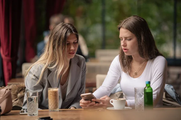 Two Attractive Sisters Discussing Something While Looking Phone — Stock Photo, Image