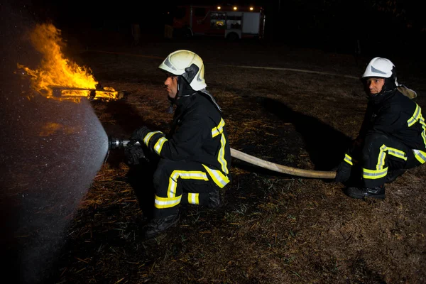 Firemen wearing protective gear during a firefighting intervention