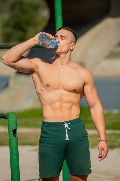 Attractive Handsome Strong Guy Drinking Water Bottle While Being Topless — Stockfoto