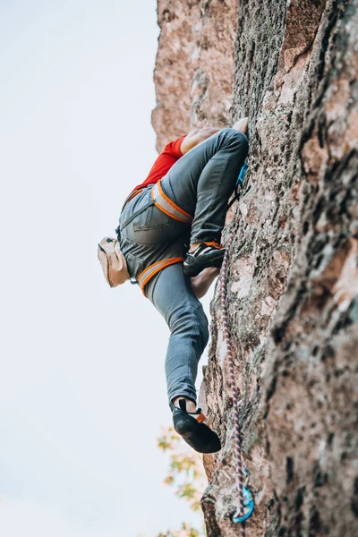 男は完全な登山機器で 安全ベルト 保険とロープでロープに岩を登る — ストック写真