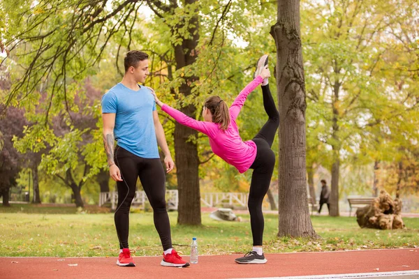 Attractive Fit Girl Stretching Her Leg While Holding Her Boyfriend — Fotografia de Stock