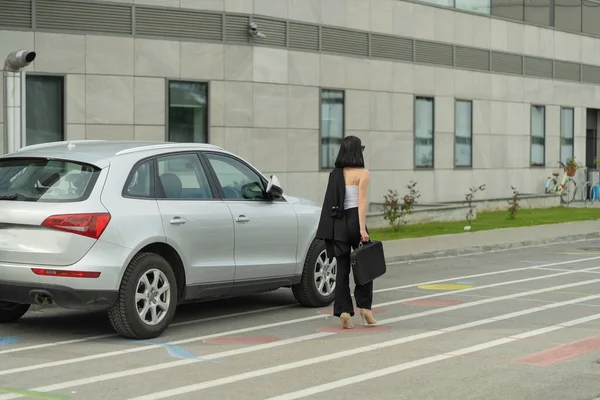 彼女はちょうど彼女の車を取得しながら魅力的なビジネス女性は会社に向かって歩いている — ストック写真