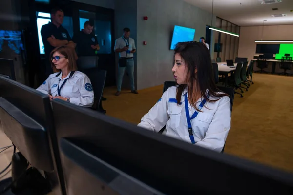 メインコントロールルームに座っている間にコンピュータ上で働く女性警備員 — ストック写真