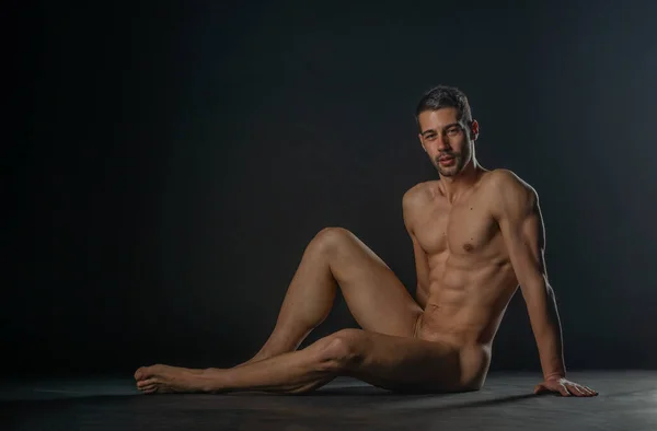 Preciosa Modelo Masculina Desnuda Sentada Aislada Suelo Estudio Mientras Mira — Foto de Stock