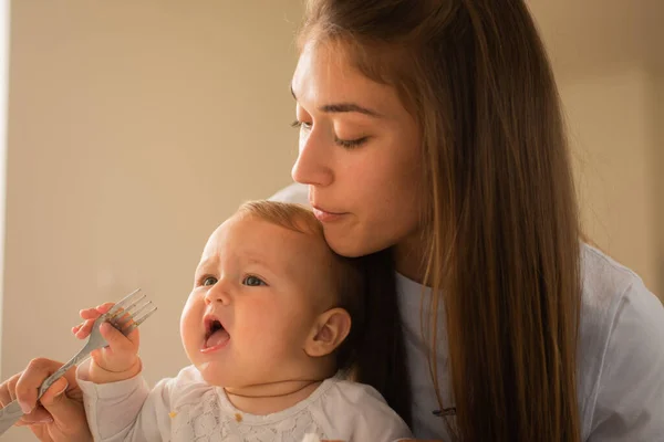 Hermosa Madre Está Tratando Sacar Tenedor Boca Del Bebé Mientras —  Fotos de Stock