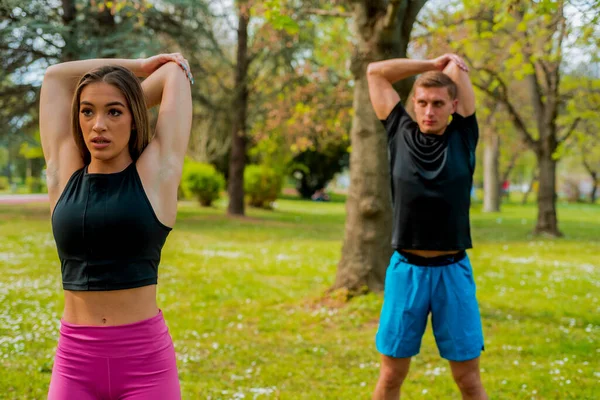 Jovens Casais Exercitando Alongando Músculos Antes Atividade Esportiva Livre Natureza — Fotografia de Stock