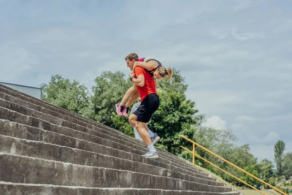Hombre Atleta Llevando Compañero Entrenamiento Femenino Sus Hombros Mientras Corre — Foto de Stock