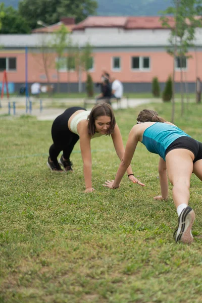Two Well Build Atttractive Girls Doing Plank Together Grass — Stock Photo, Image
