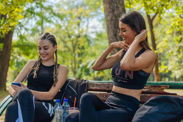 Hete Aantrekkelijke Vrouwen Glimlachen Vegen Hun Telefoons Terwijl Een Park — Stockfoto
