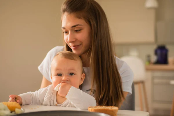Mooie Moeder Holding Haar Baby Meisje Terwijl Eet — Stockfoto