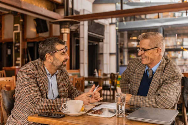 Δύο Ανώτεροι Επιχειρηματίες Συζητούν Σοβαρά Για Συνάντησή Τους Στο Καφέ — Φωτογραφία Αρχείου