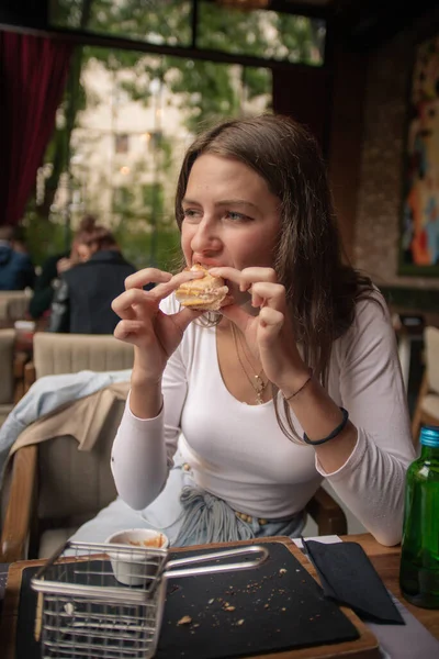 魅力的で素晴らしい女の子はそれを食べながらレストランで彼女の食べ物を楽しんでいます — ストック写真