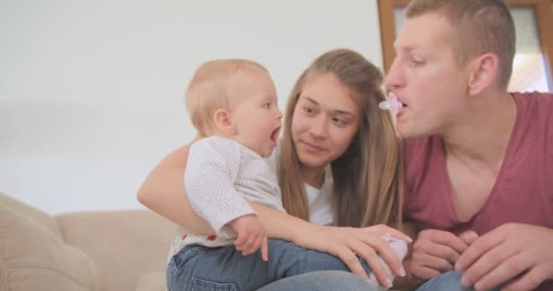 Родители Развлекают Свою Счастливую Дочь Соской Простыми Жестами Рук — стоковое видео