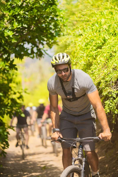 英俊而健康的男人骑着自己的自行车被人跟踪的画像 — 图库照片