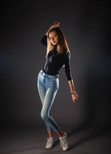 魅力的な女性モデルでデニムジーンズポージング絶縁上のグレーの背景 — ストック写真