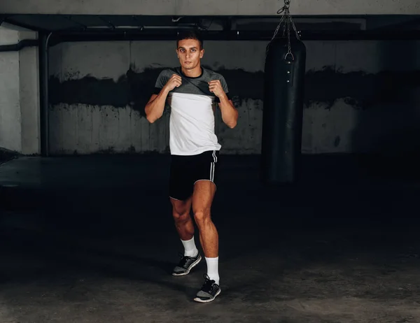 Young male boxer practicing shadow boxing