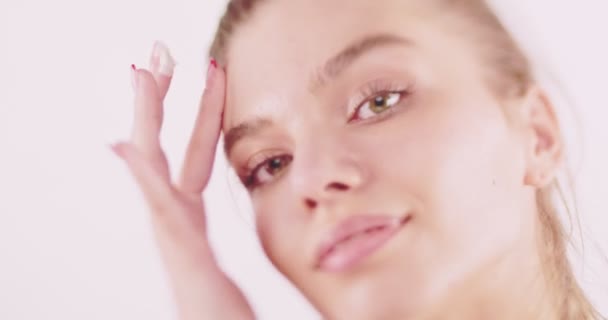 Mooi Meisje Aanbrengen Witte Crème Haar Voorhoofd Geïsoleerd Beige Achtergrond — Stockvideo